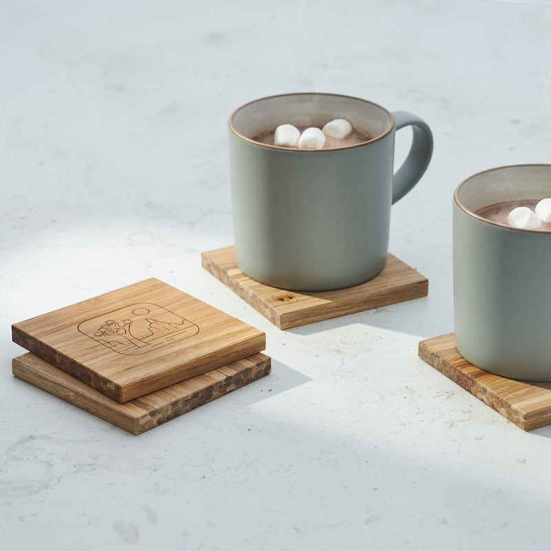 four coasters and two mugs of hot chocolate