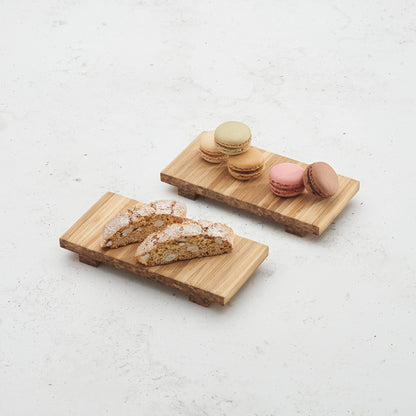 two heyday breakfast trays sitting on the counter top, one with five macarons on top, another with 2 biscotti on top 