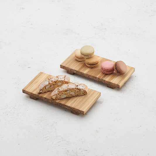 two heyday breakfast trays sitting on the counter top, one with five macarons on top, another with 2 biscotti on top 