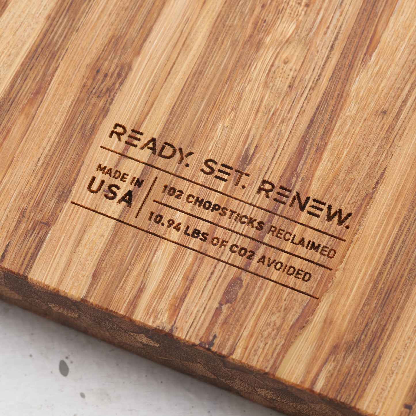 impact metrics on the back of board saying 102 chopsticks reclaimed, 10.94 lbs of co2 avoided