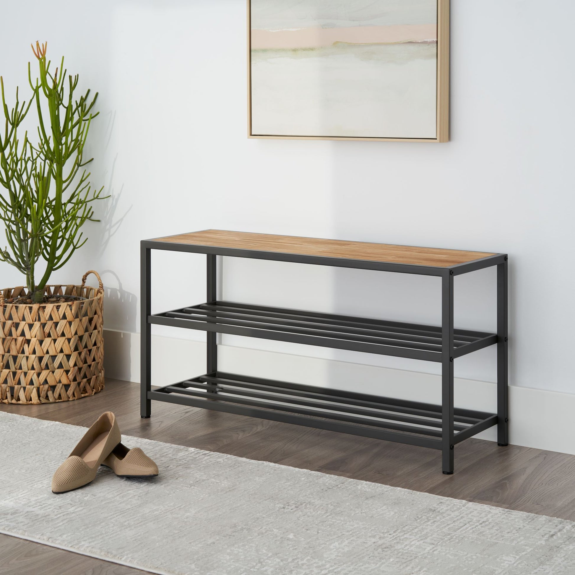 three tier shoe rack featuring a chopstick made wood top placed in a living room entry way with nothing on the shelves