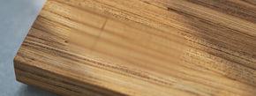 The corner of a cutting board made of recycled chopsticks, reading Renew, Made in the USA, 577 chopsticks reclaimed, 61.85 pounds of CO2 avoided.